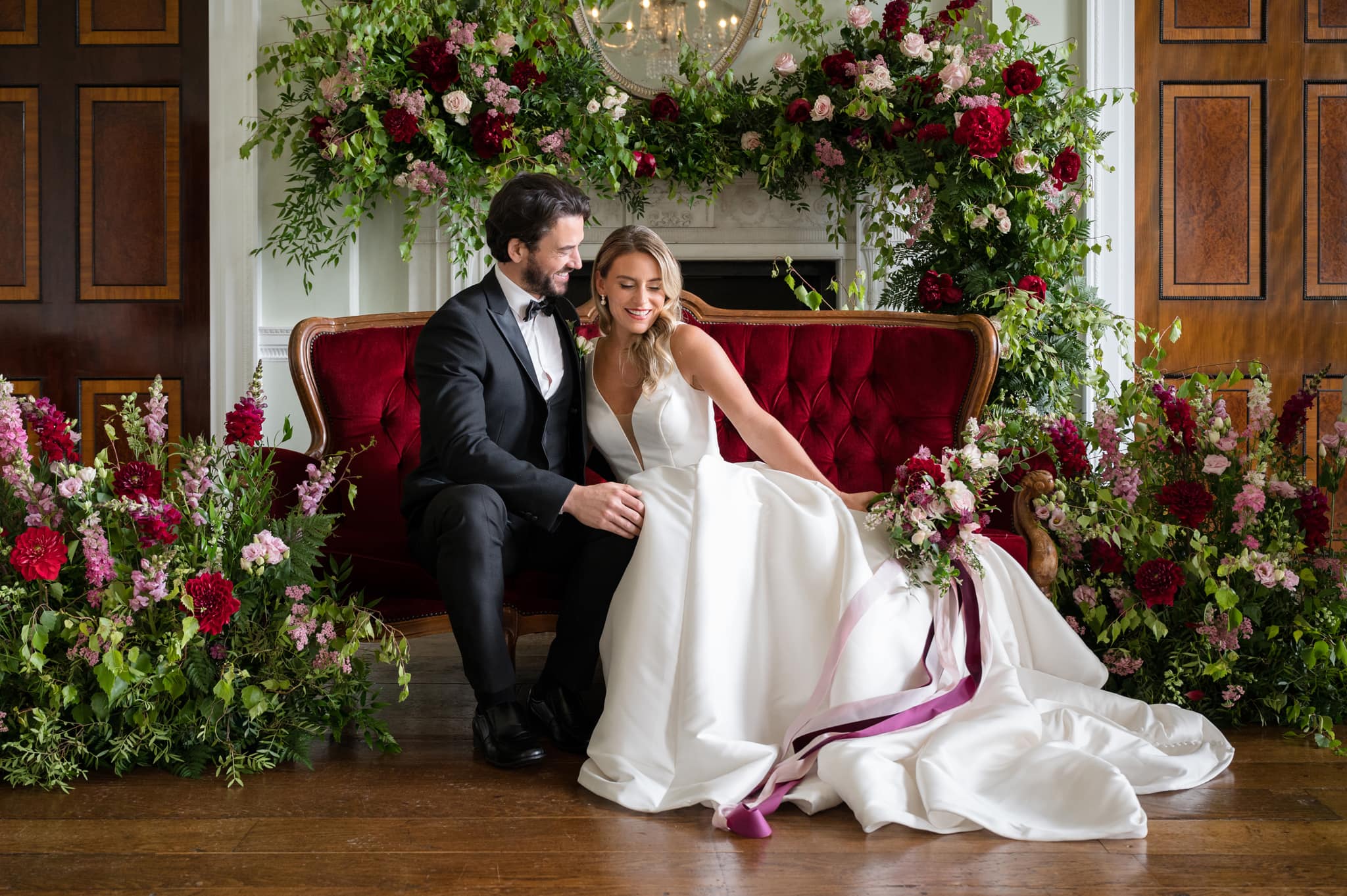 Bride & groom sitting on red sofa