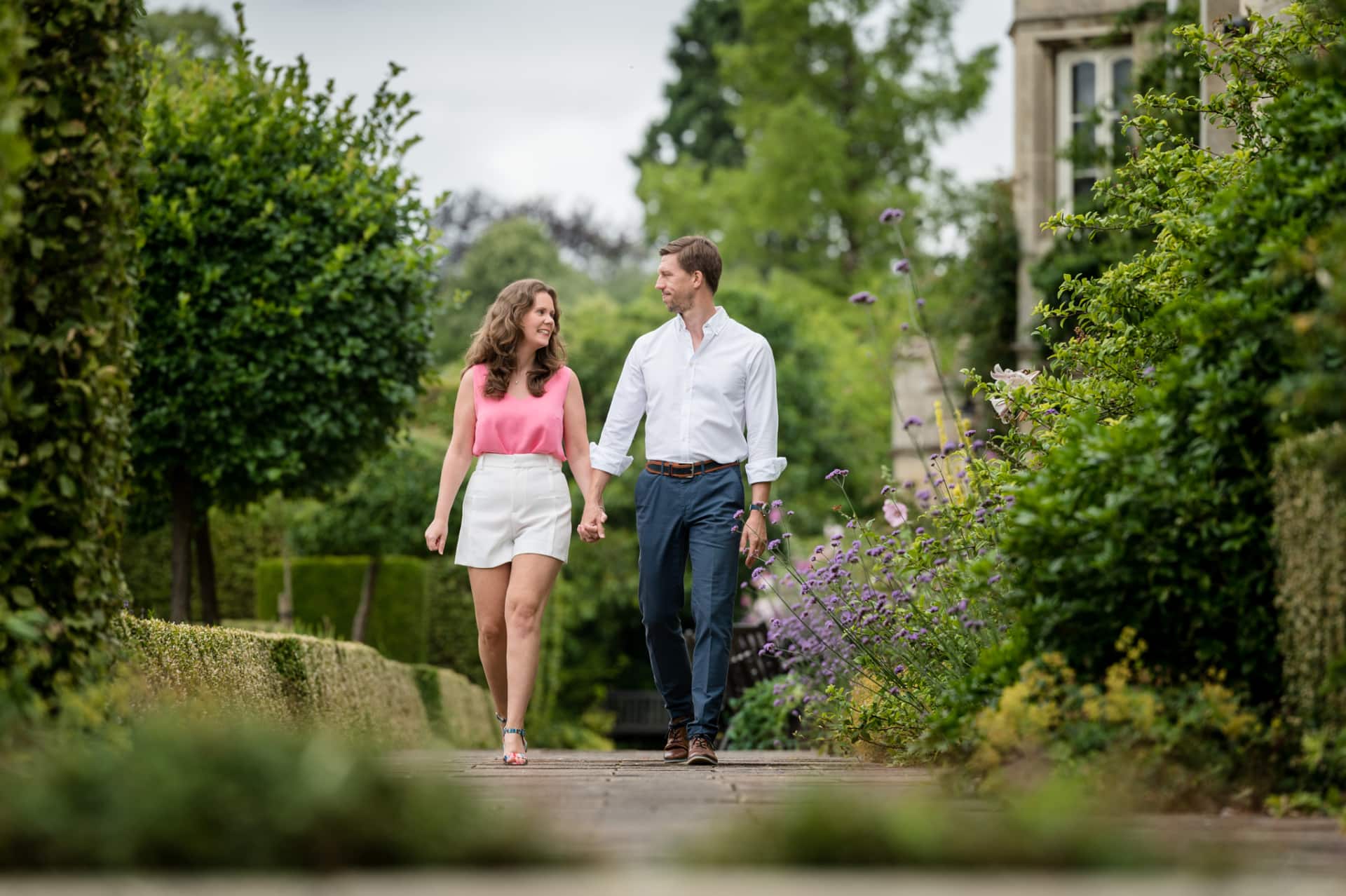 Engaged couple walking along the terrace at Deene Park