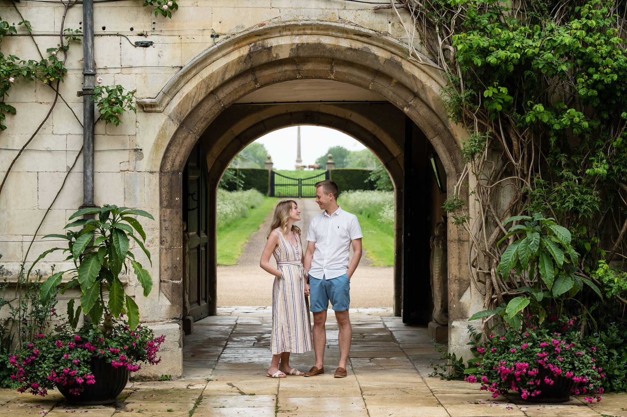 Engaged couple standing under entrance arch