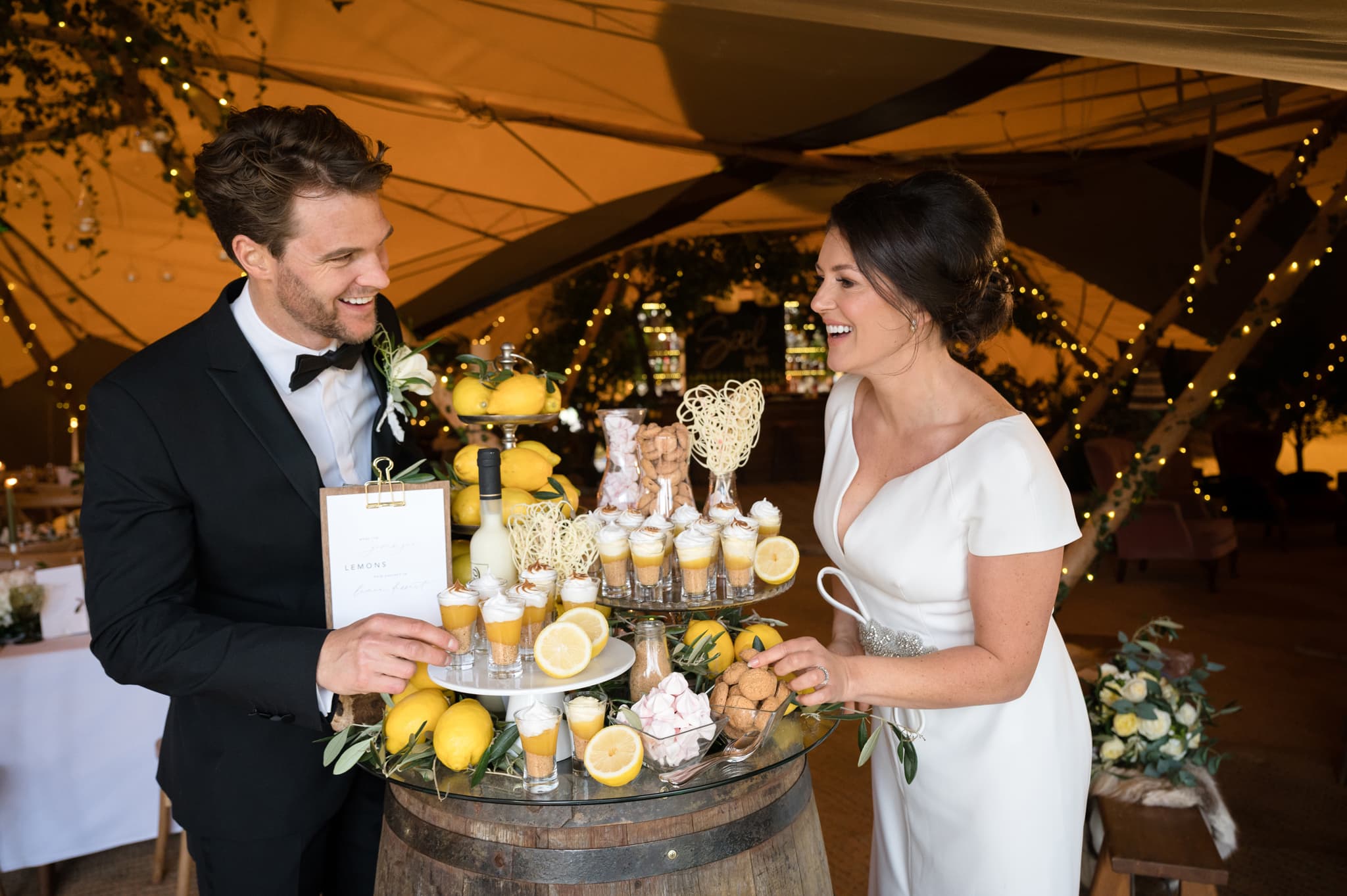 Bride and groom tucking into lemon themed desserts