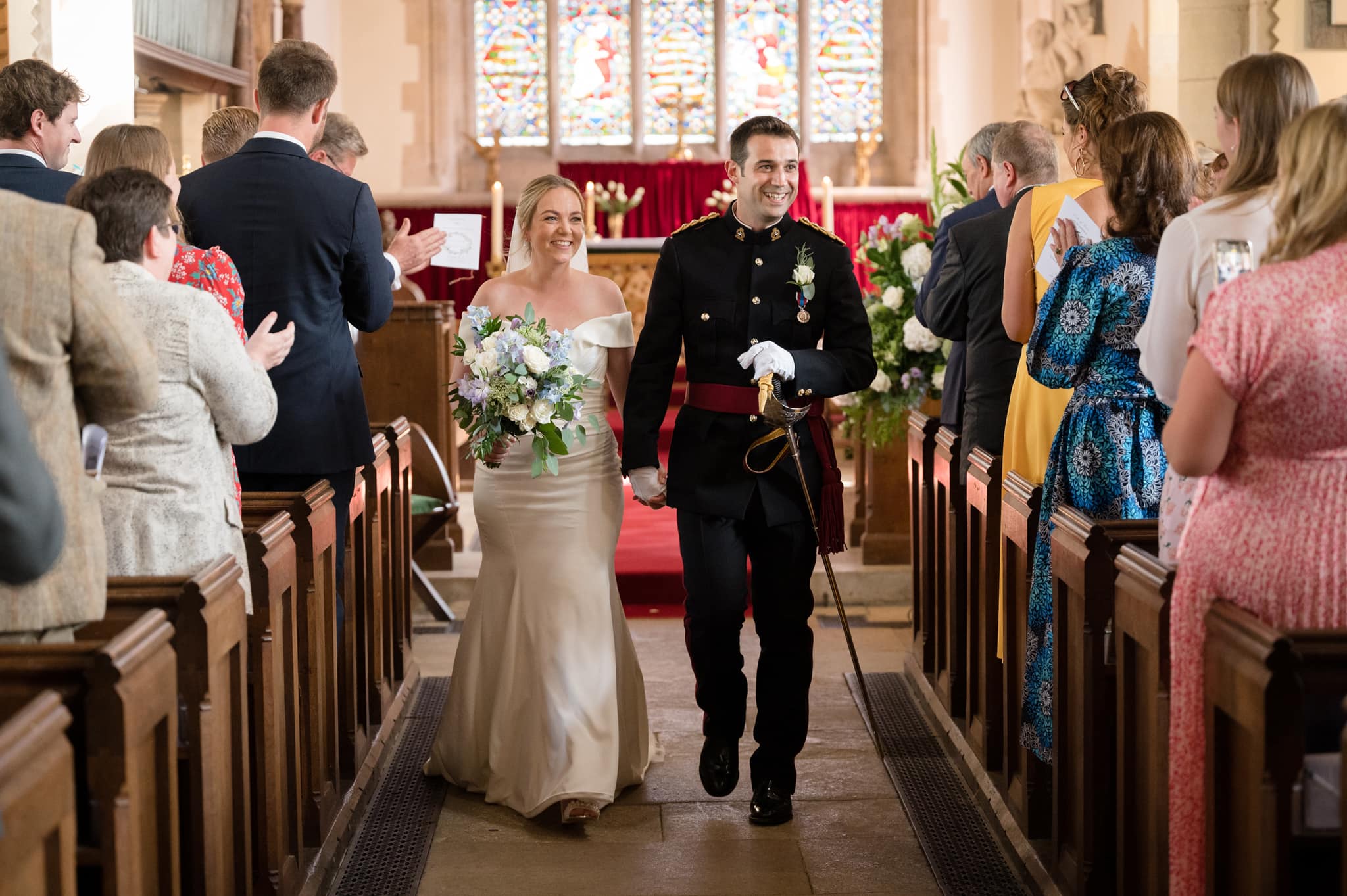 Bride and groom beaming as they walk down aisle