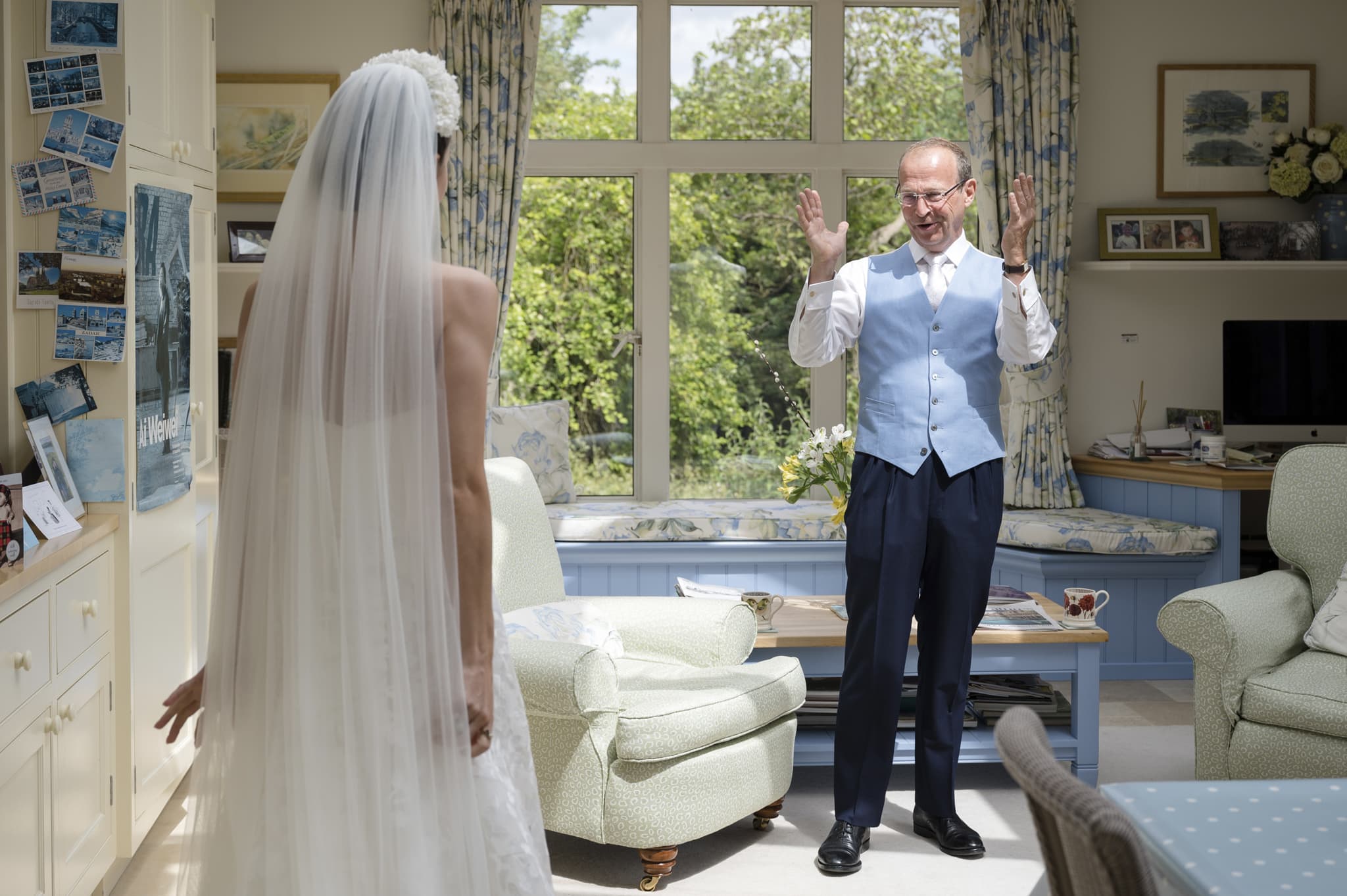 Father of the Bride's surprised and delighted reaction to seeing his daughter walk into the room in her dress