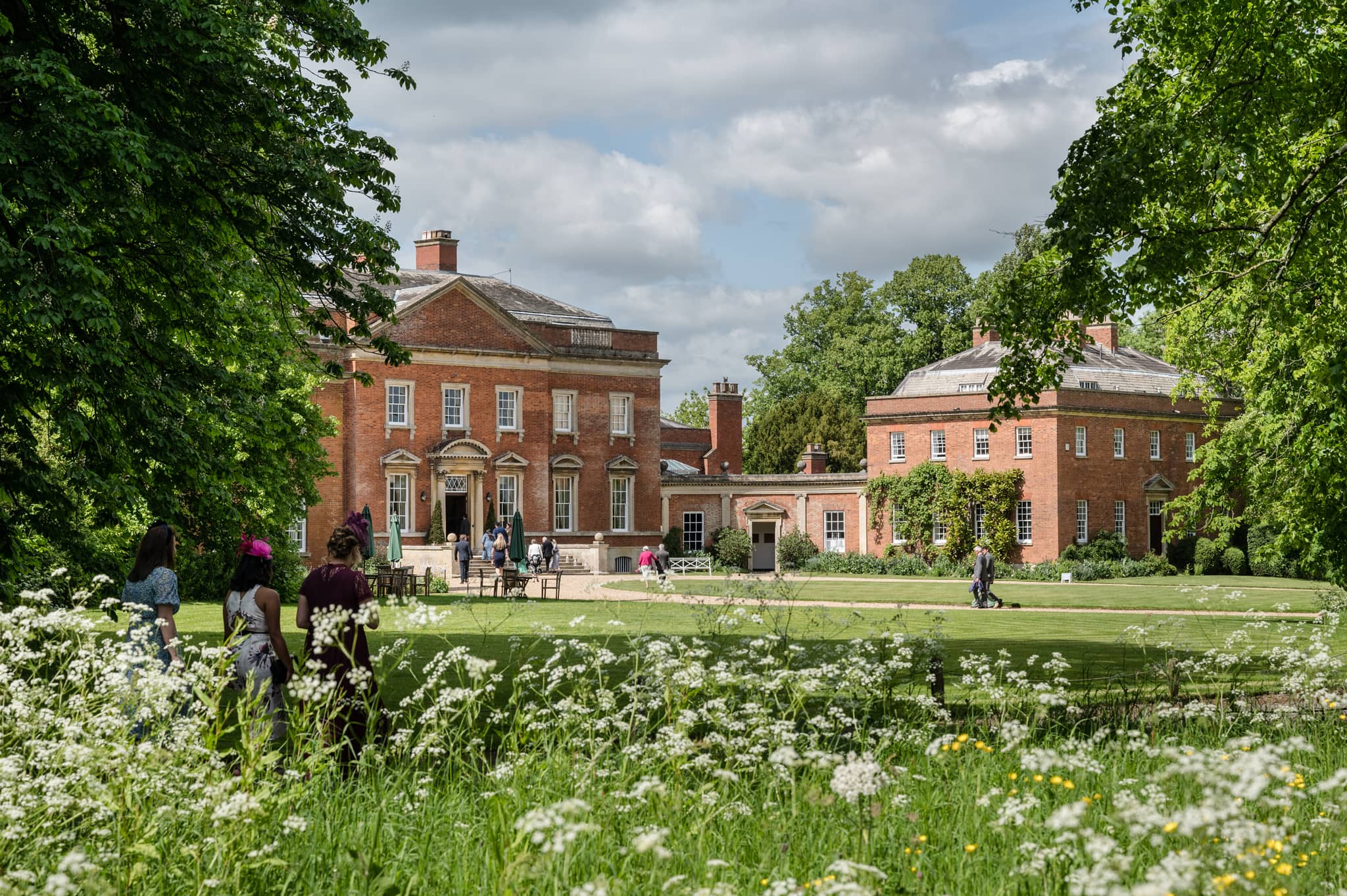 A view of Kelmarsh Hall with wedding guests arriving