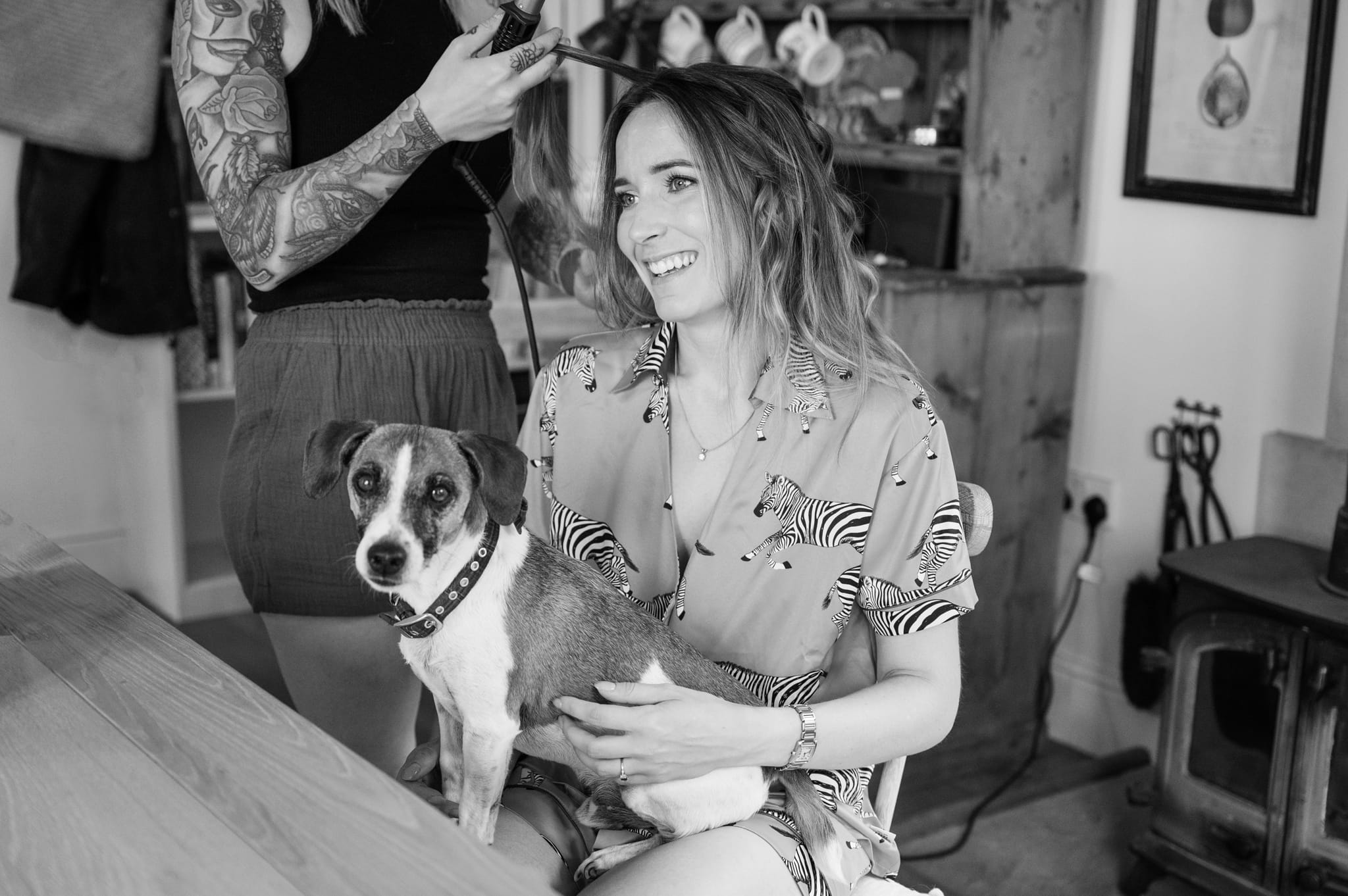 The bride having her hair done by hair stylist Liz Staniland while her Jack Russell dog sits on her lap