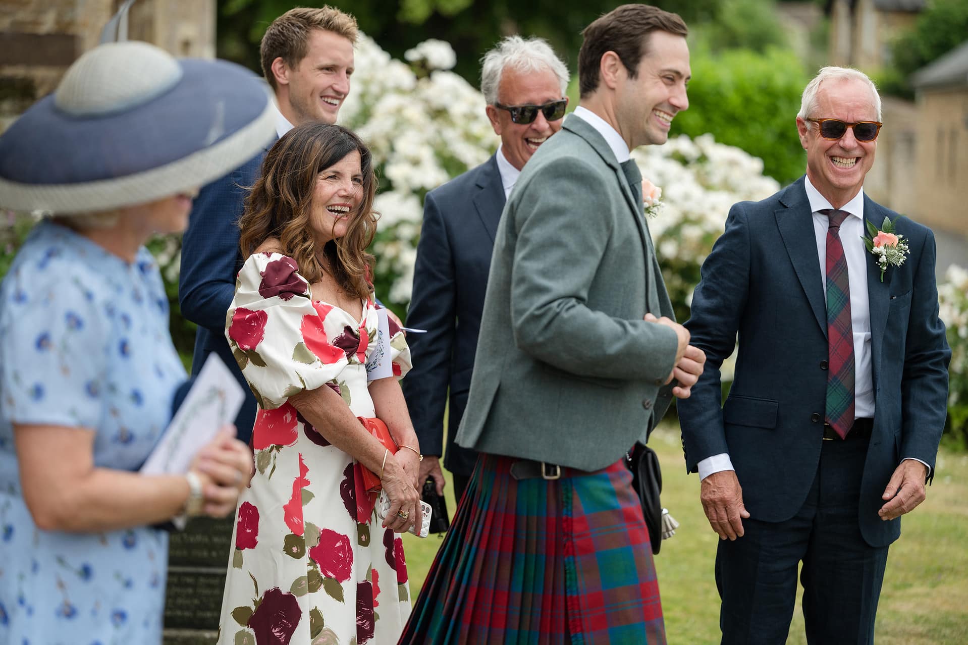 The groom laughing with his family ouside Wing church in Rutland