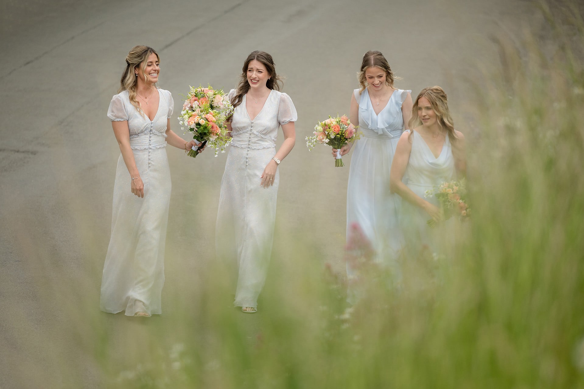 Four bridesmaids in pale blue dresses arriving at Wing church in Rutland