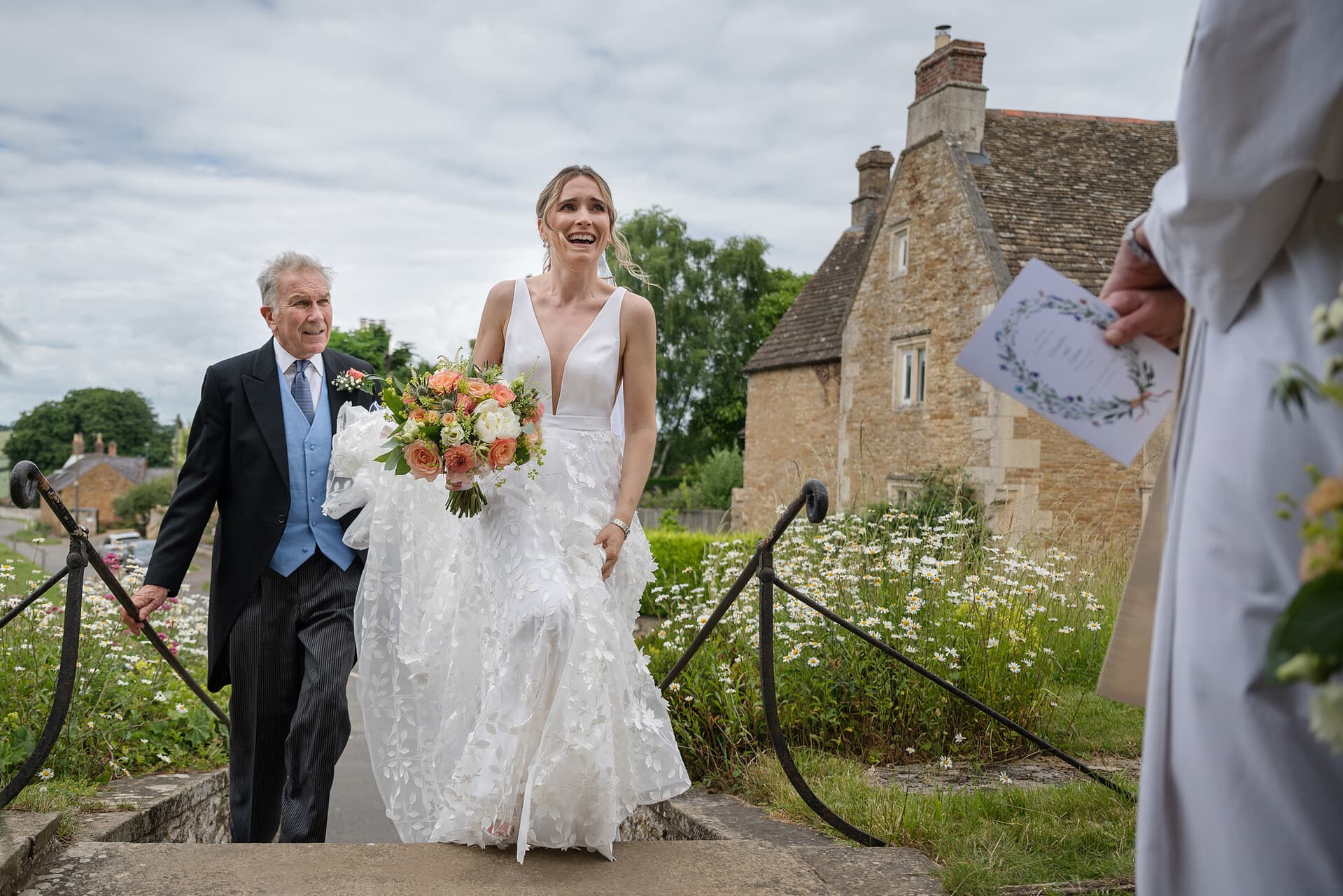 The bride and her dad walking up the steps to Wing church in Rutland