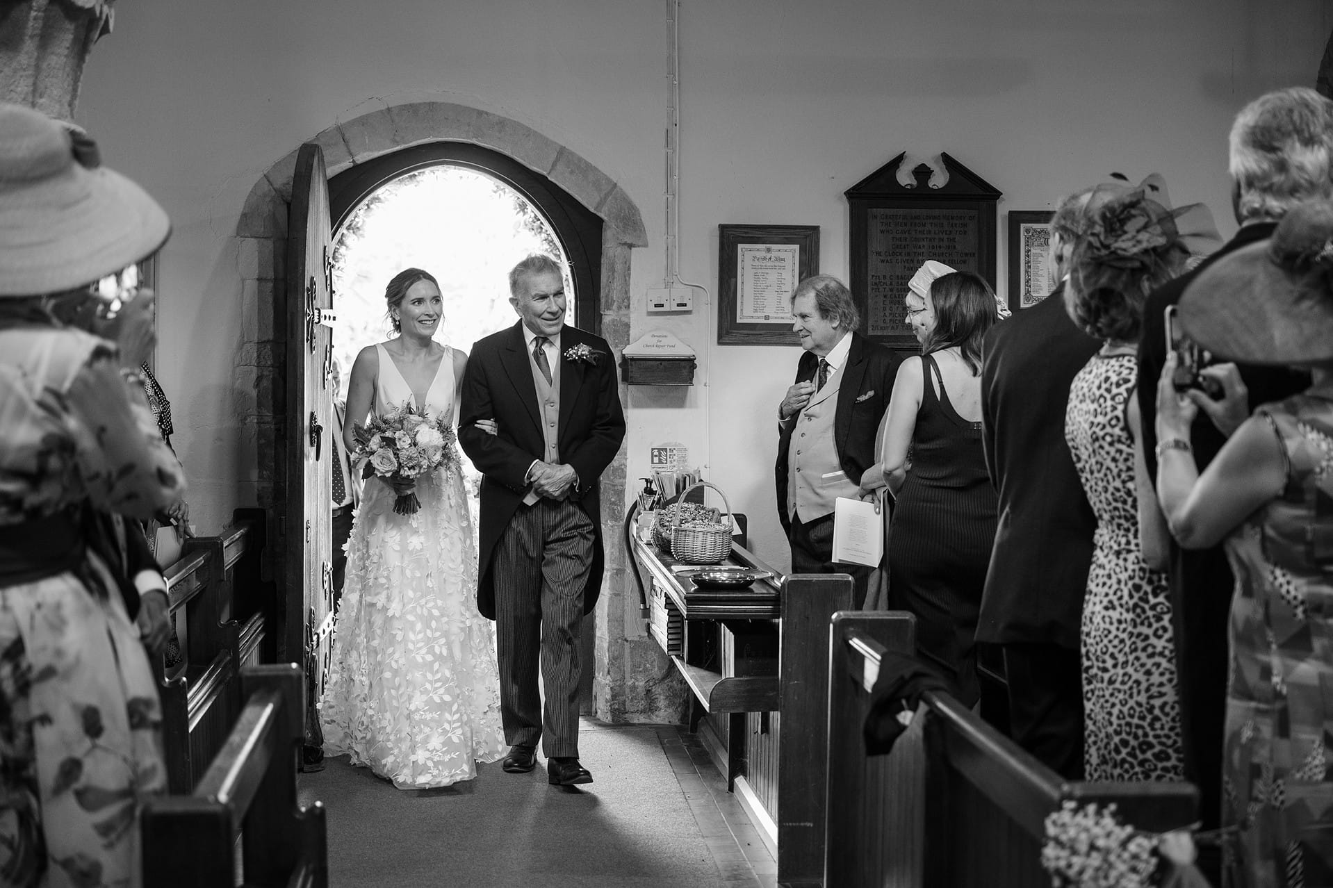 Bride and her dad walking through the door to process down the aisle at Wing church in Rutland