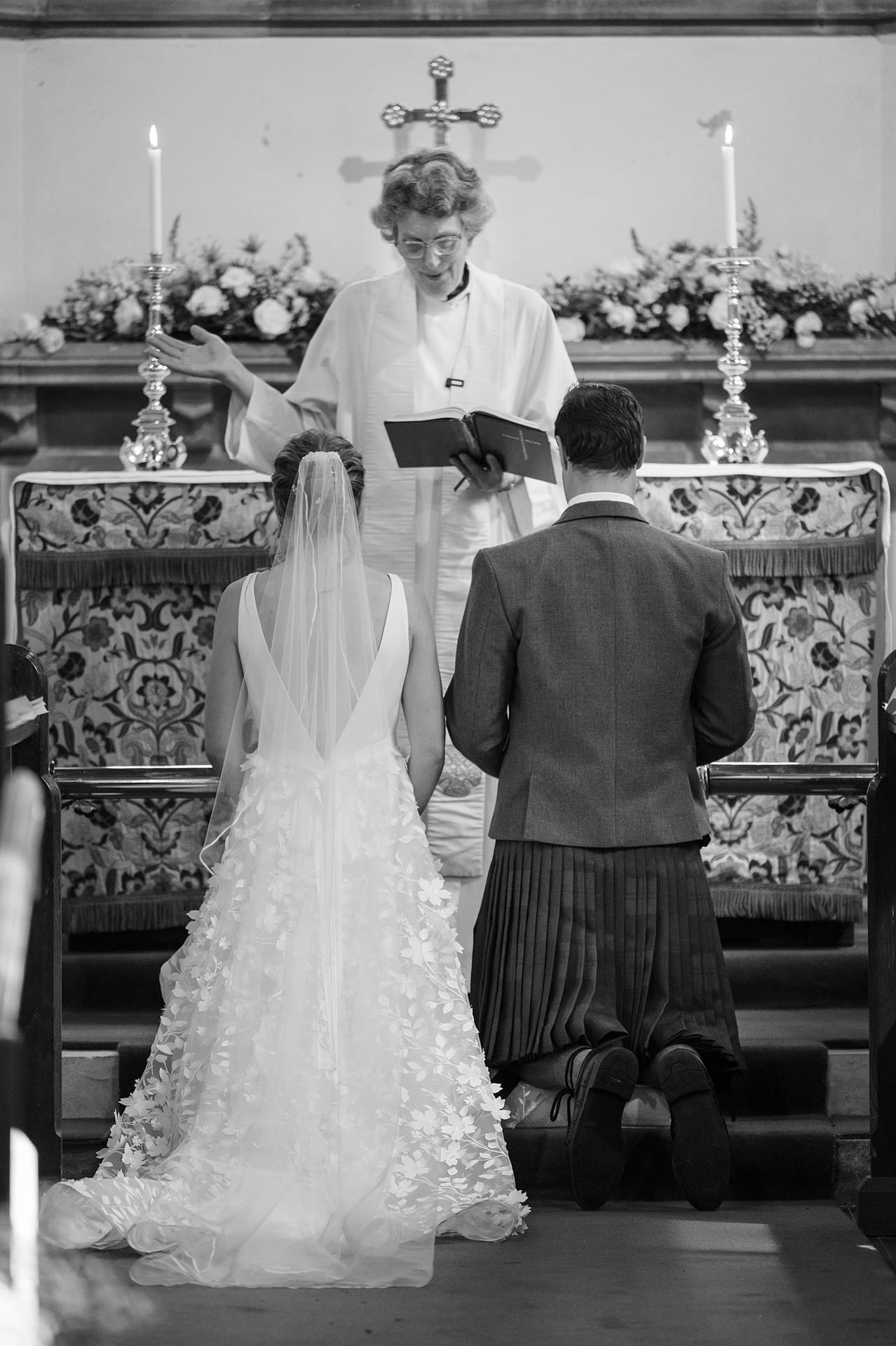 The bride and groom kneeling for the prayers during their wedding ceremony at Wing church in Rutland