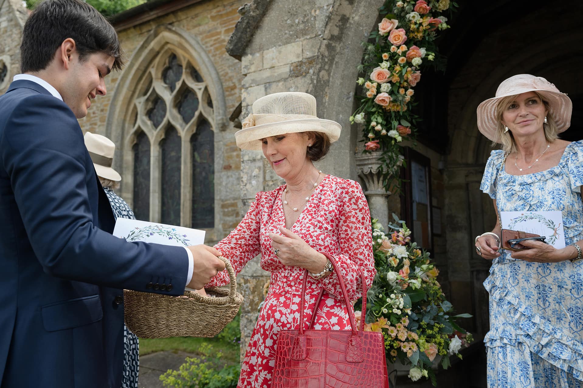 Wedding guests taking confetti from a basket at Wing church in Rutland