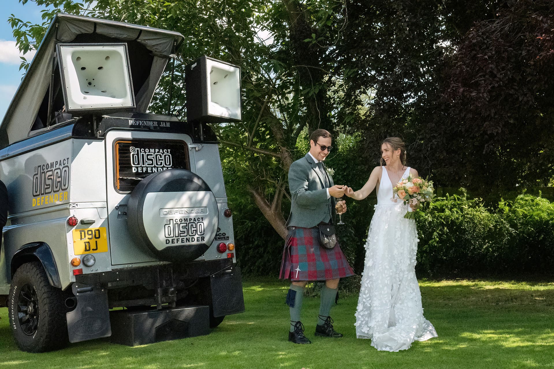 Bride and groom dancing next to a 'Disco Defender' - a DJ in a Landrover