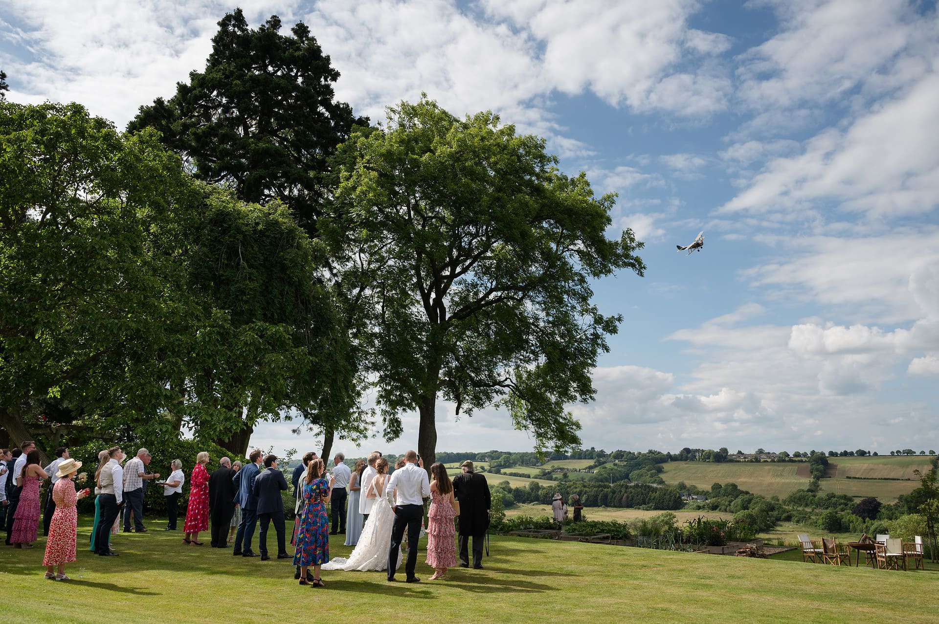 Wedding guests watching a vintage tiger moth plane fly past