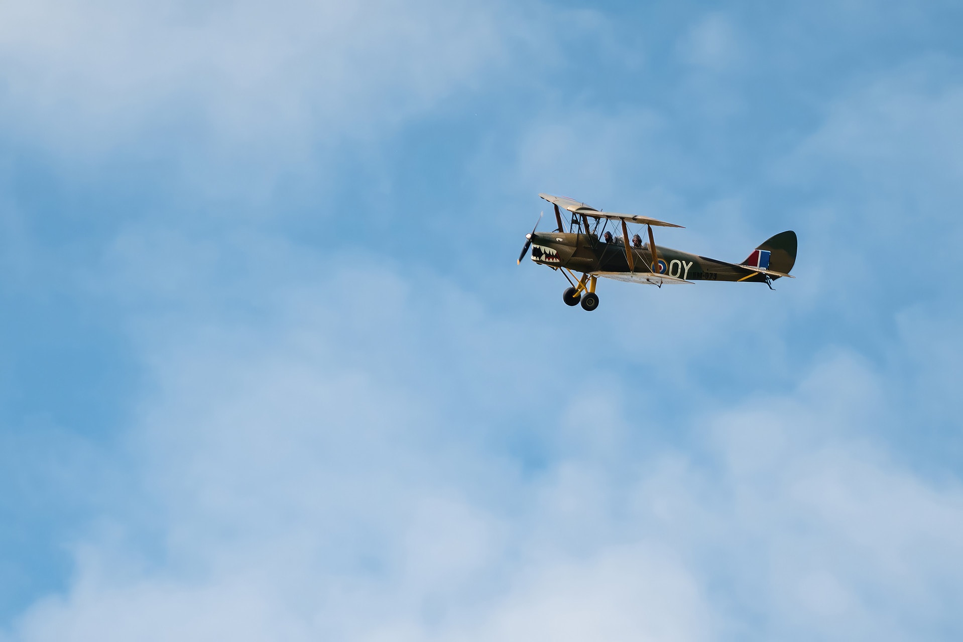 A vintage tiger moth plane flying through the sky