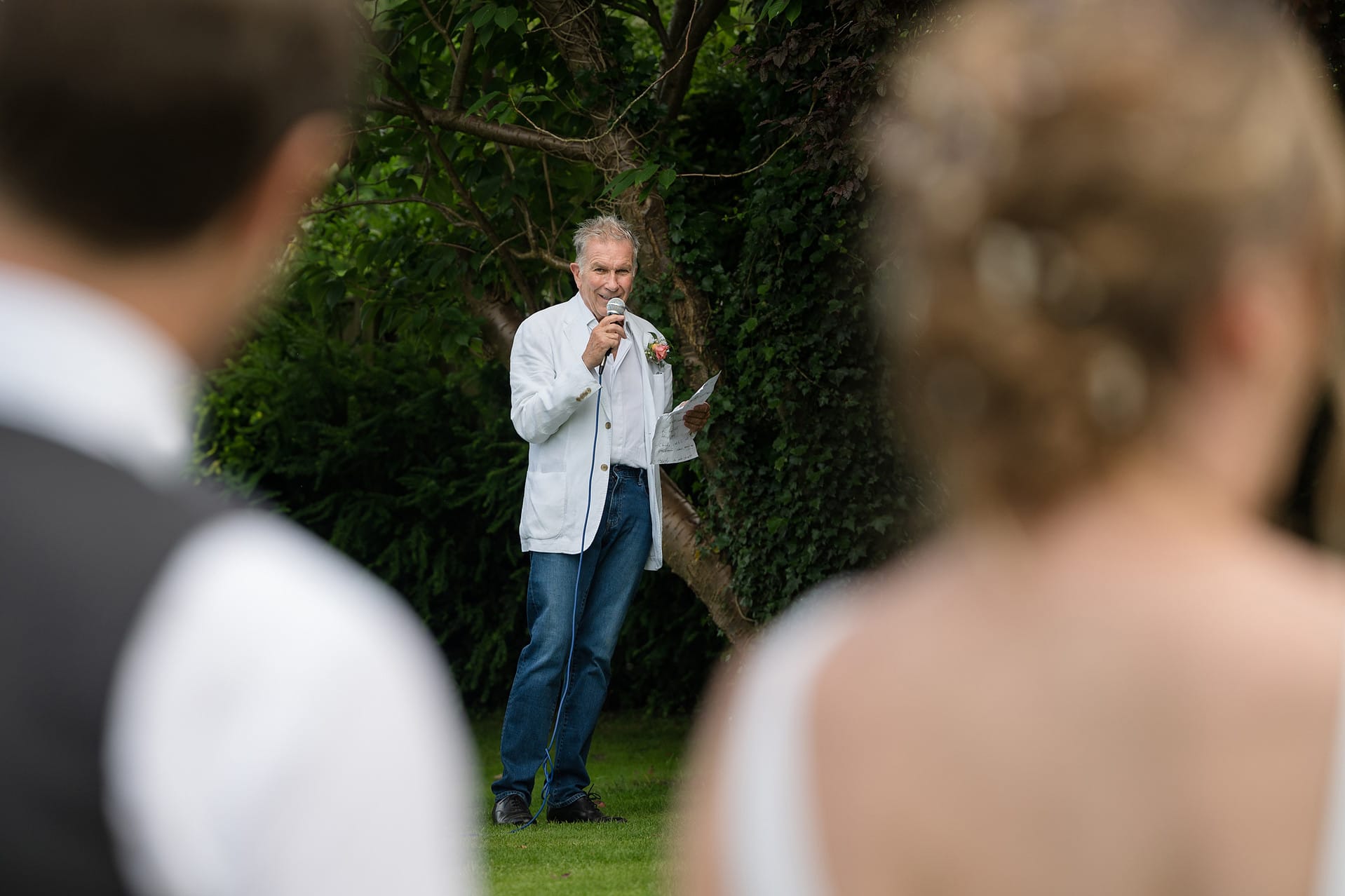 The bride's dad making his speech shot from behind the bride and groom