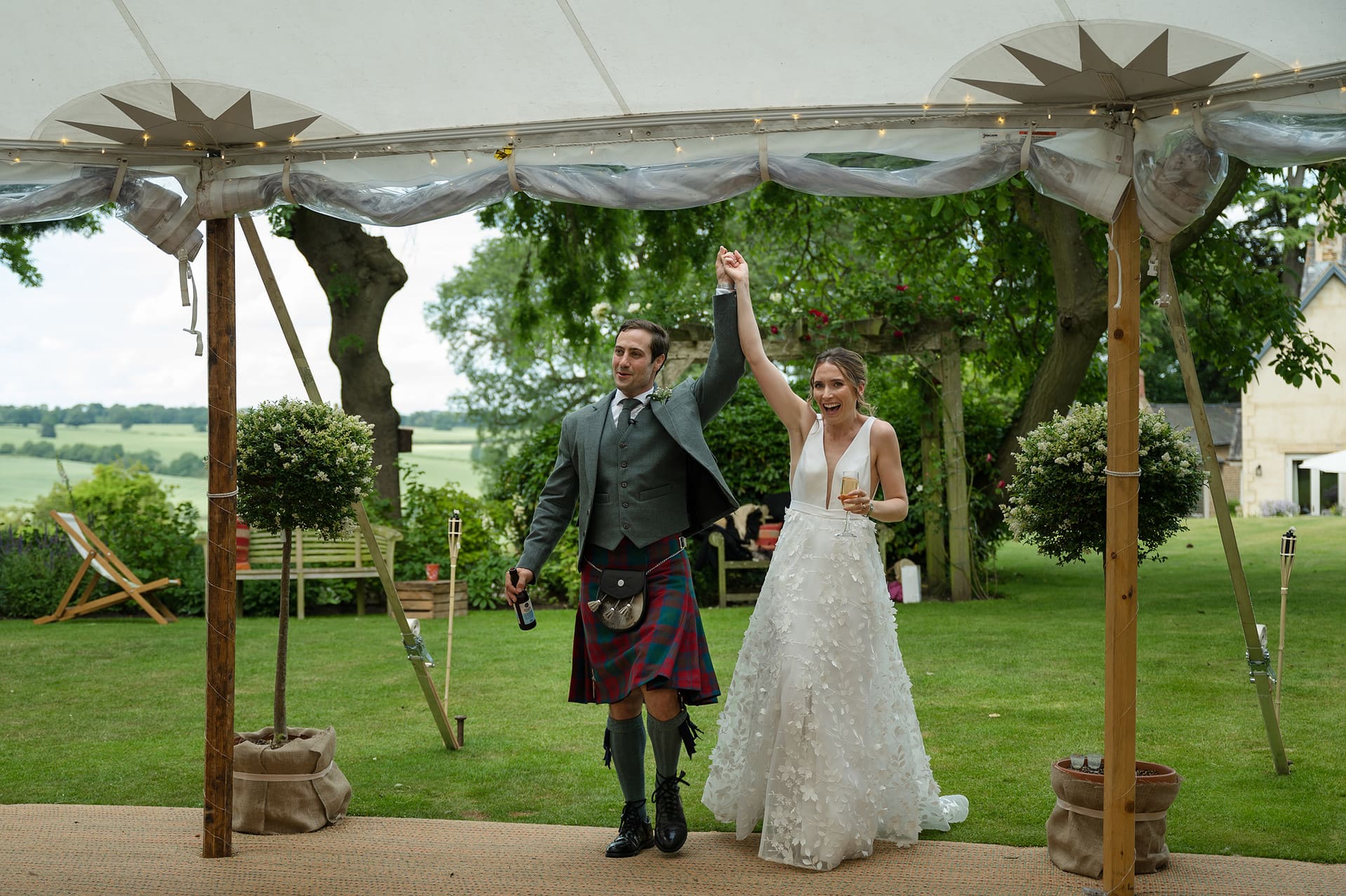 The bride and groom making a big entrance into the marquee for their wedding breakfast