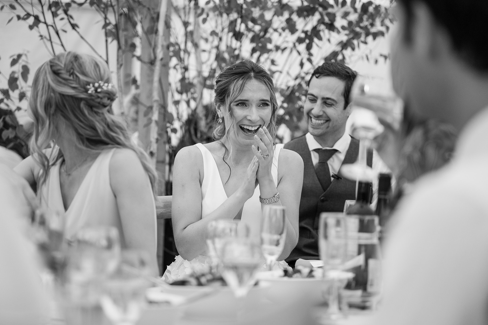 The bride clapping and laughing at the best man's speech