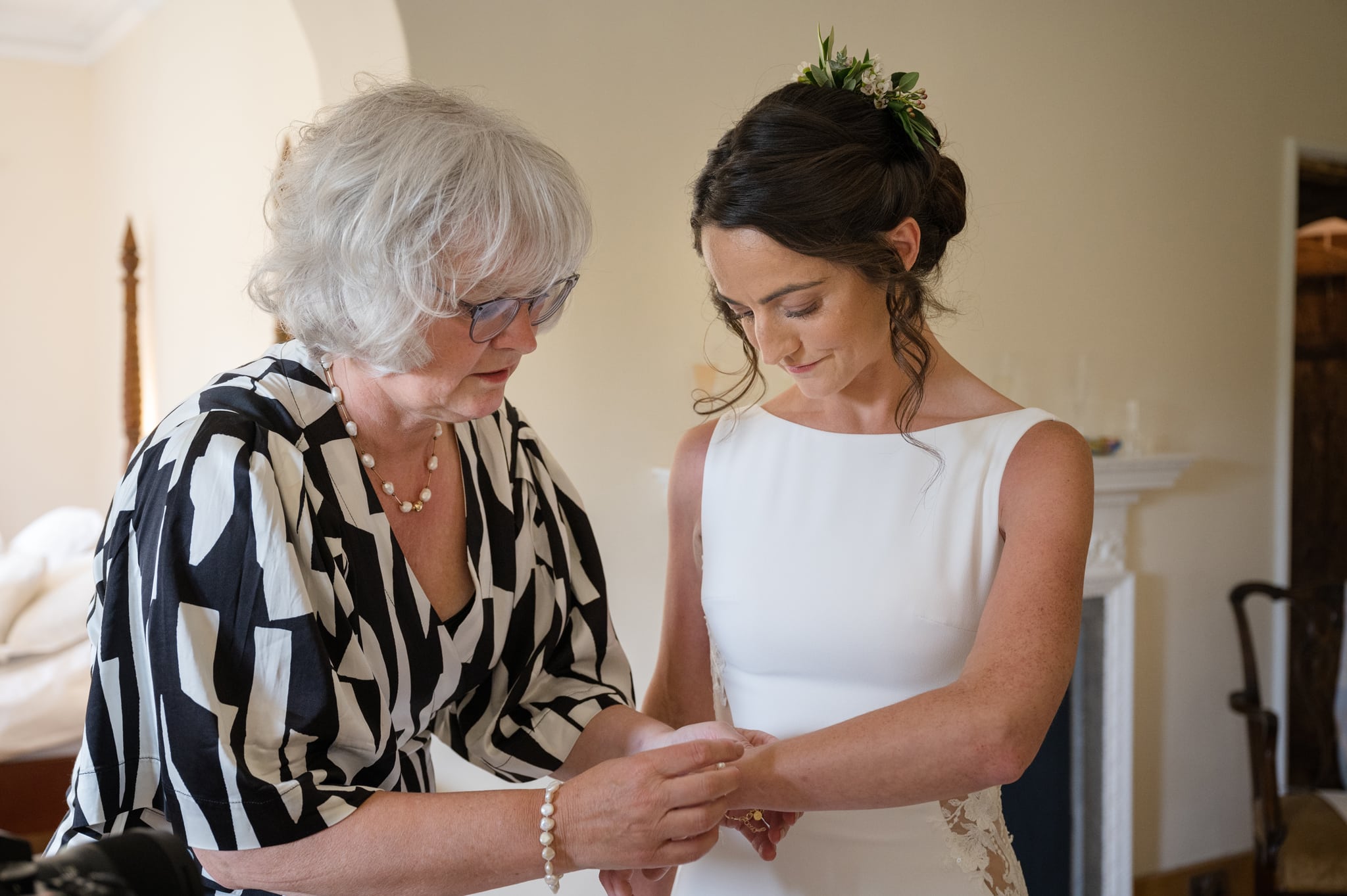 Bride's mum putting a bracelet on the bride's wrist